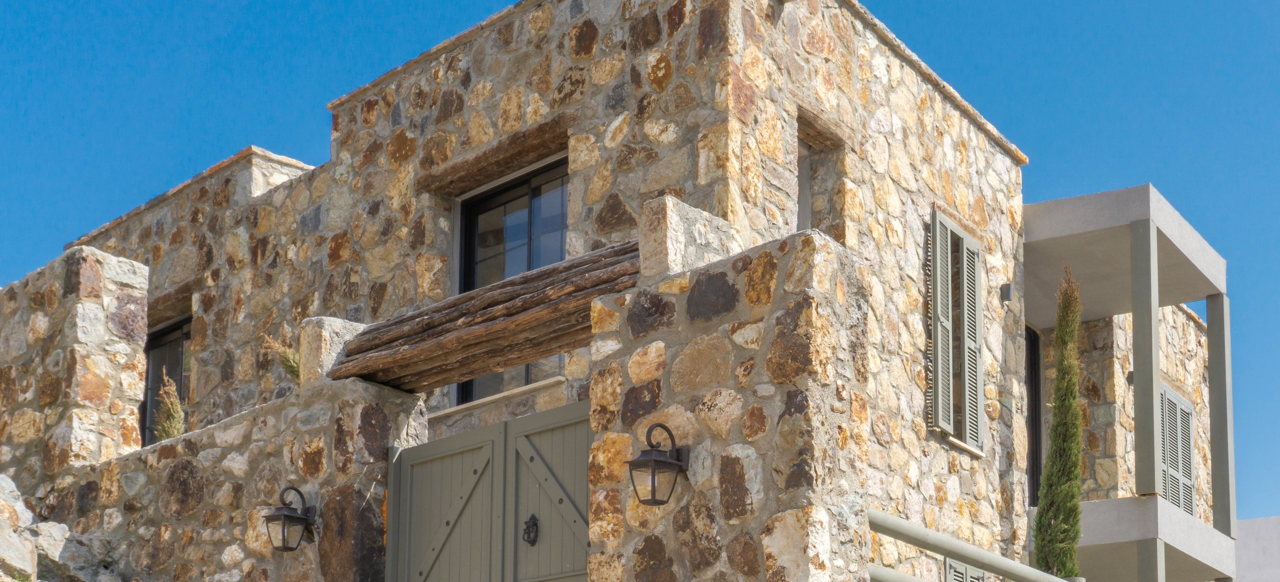 The Stone House, a stone facade with a green timber door